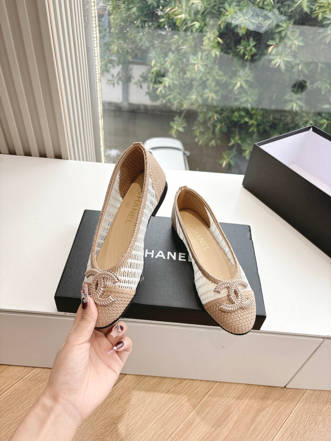 Chanel ladies beige woven ballet flats held in hand, with bow detail