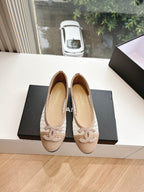 Chanel ladies beige woven ballet flats on a black box, front view
