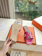 Hermes pink croc-pattern slide sandals, sole and back tag visible