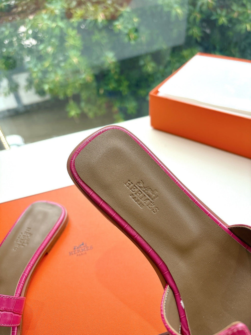 Hermes pink croc-pattern slide sandals, close-up of tan footbed detail