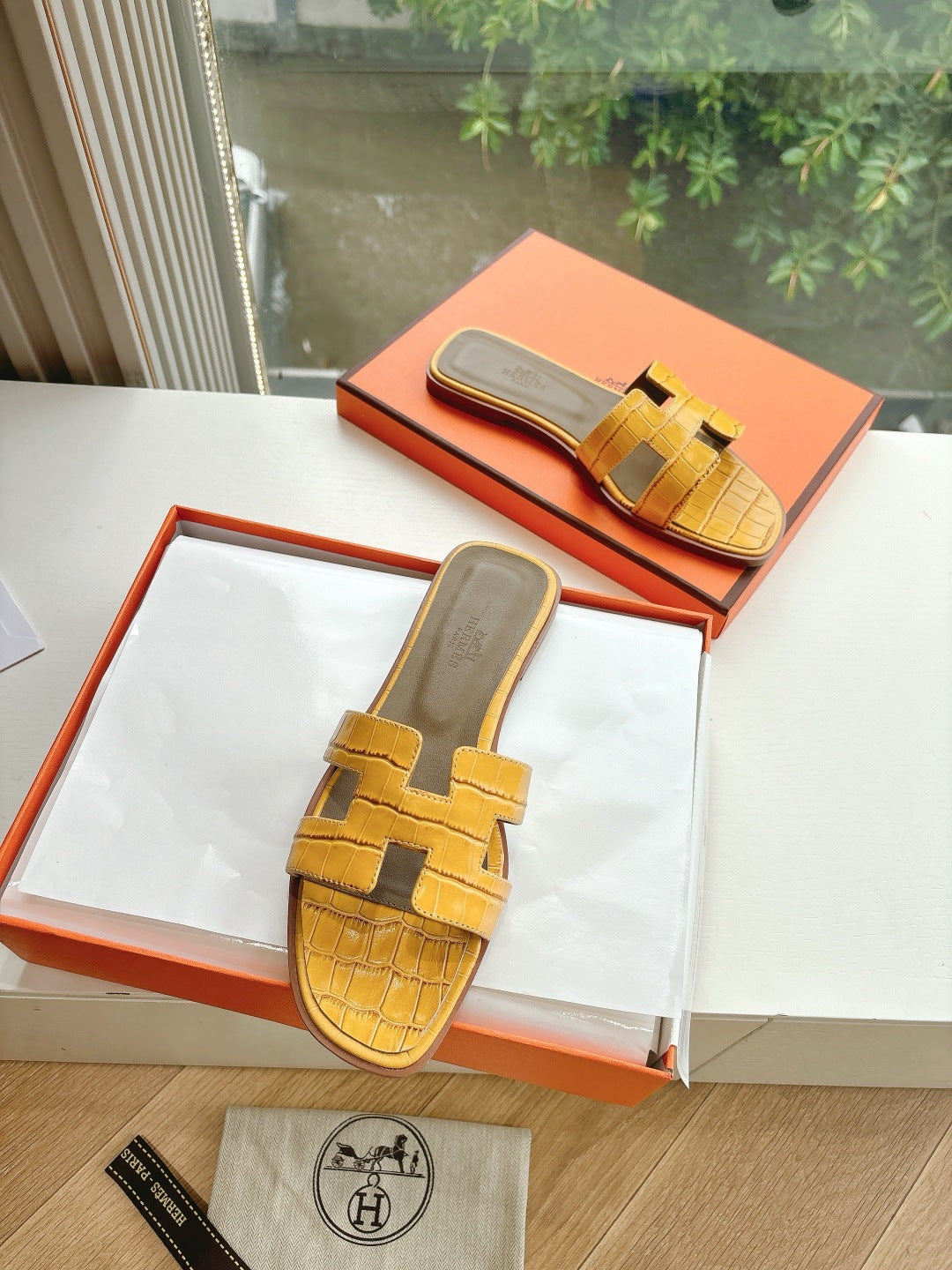 Women’s yellow croc-embossed slide sandals in a box, with cross-strap design
