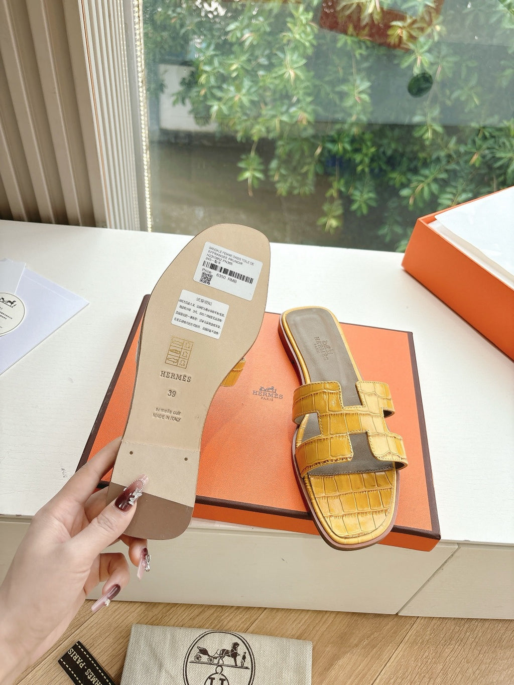 Women’s yellow croc-embossed slide sandals with cross straps, shown on box insert