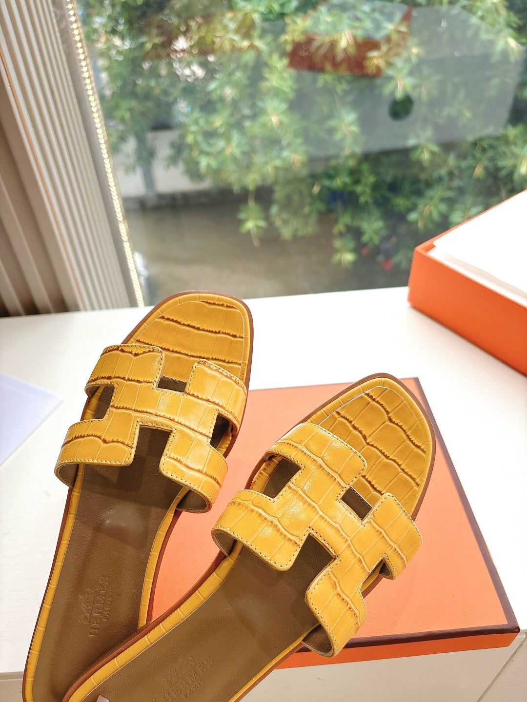 Women’s yellow croc-embossed slide sandals, angled view showing strap and insole