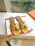 Women’s yellow croc-embossed slide sandals with cross straps and padded footbed