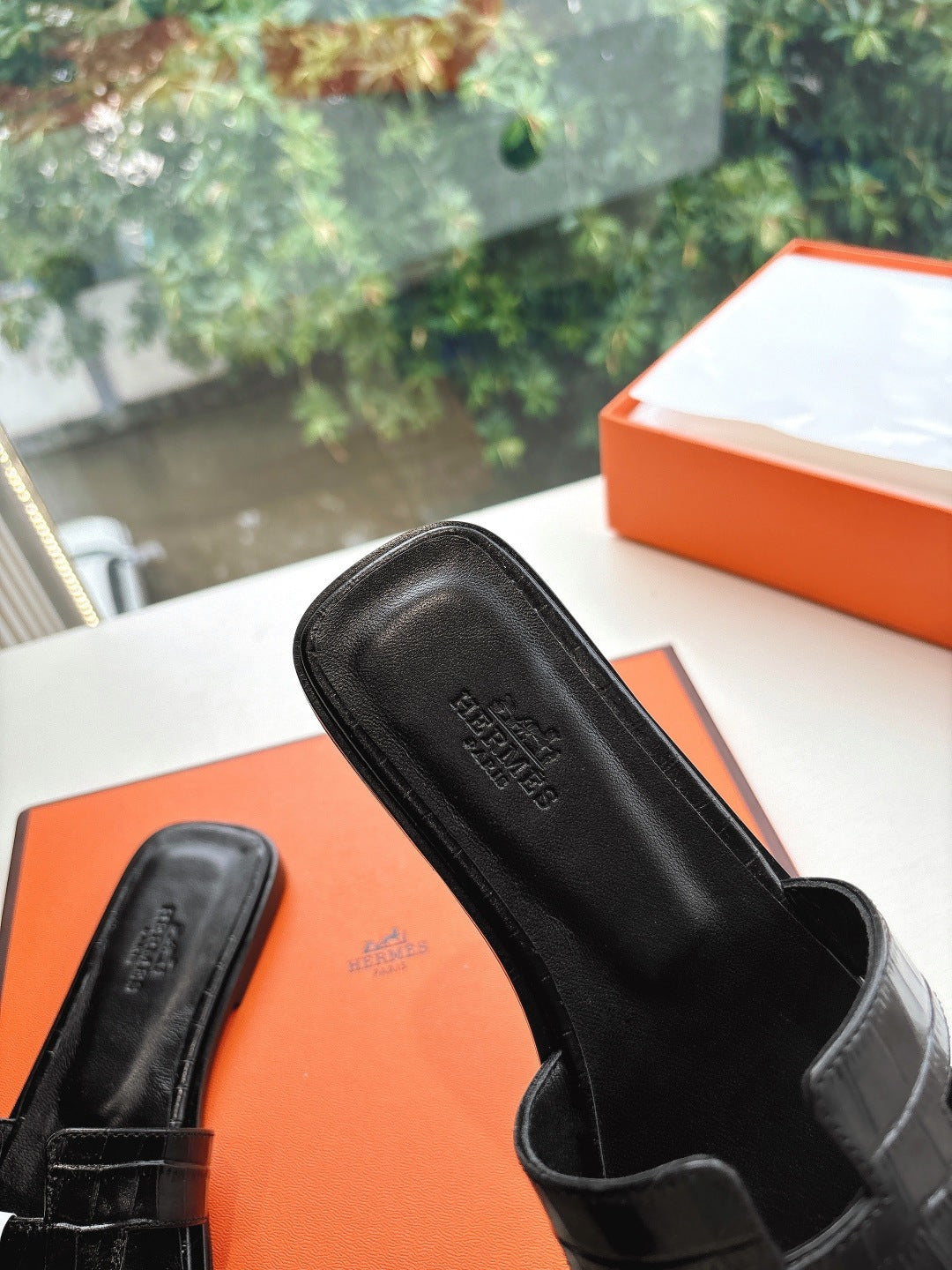 Black slide sandal with embossed footbed lettering and textured slide upper