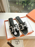 Black and white Hermes slide sandals with H-style straps, in orange gift box.