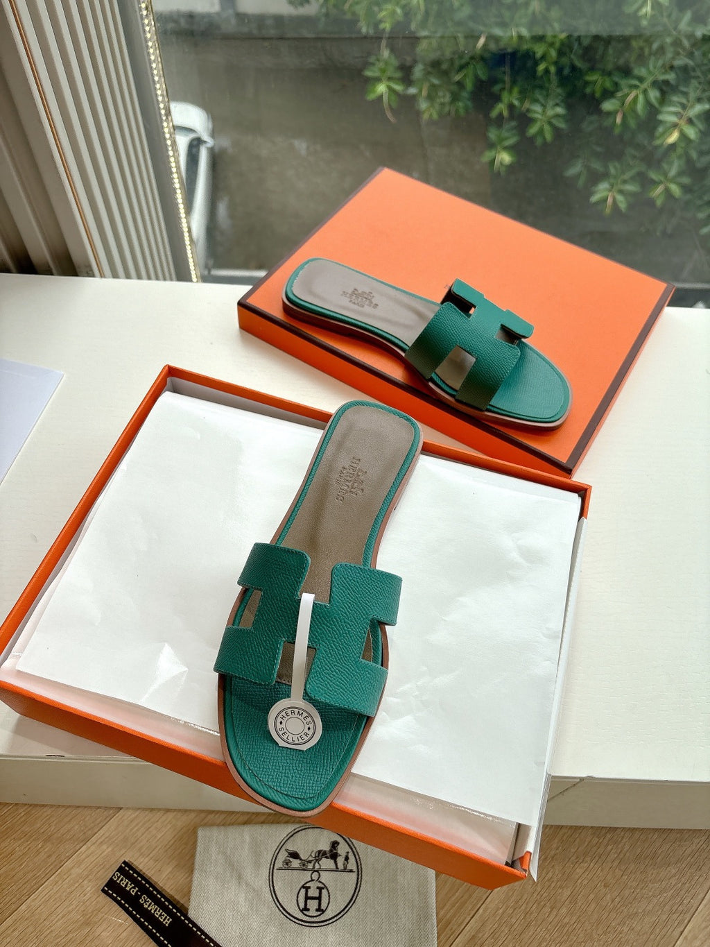 Hermes ladies slide sandals, teal green with H strap detail on boxed display
