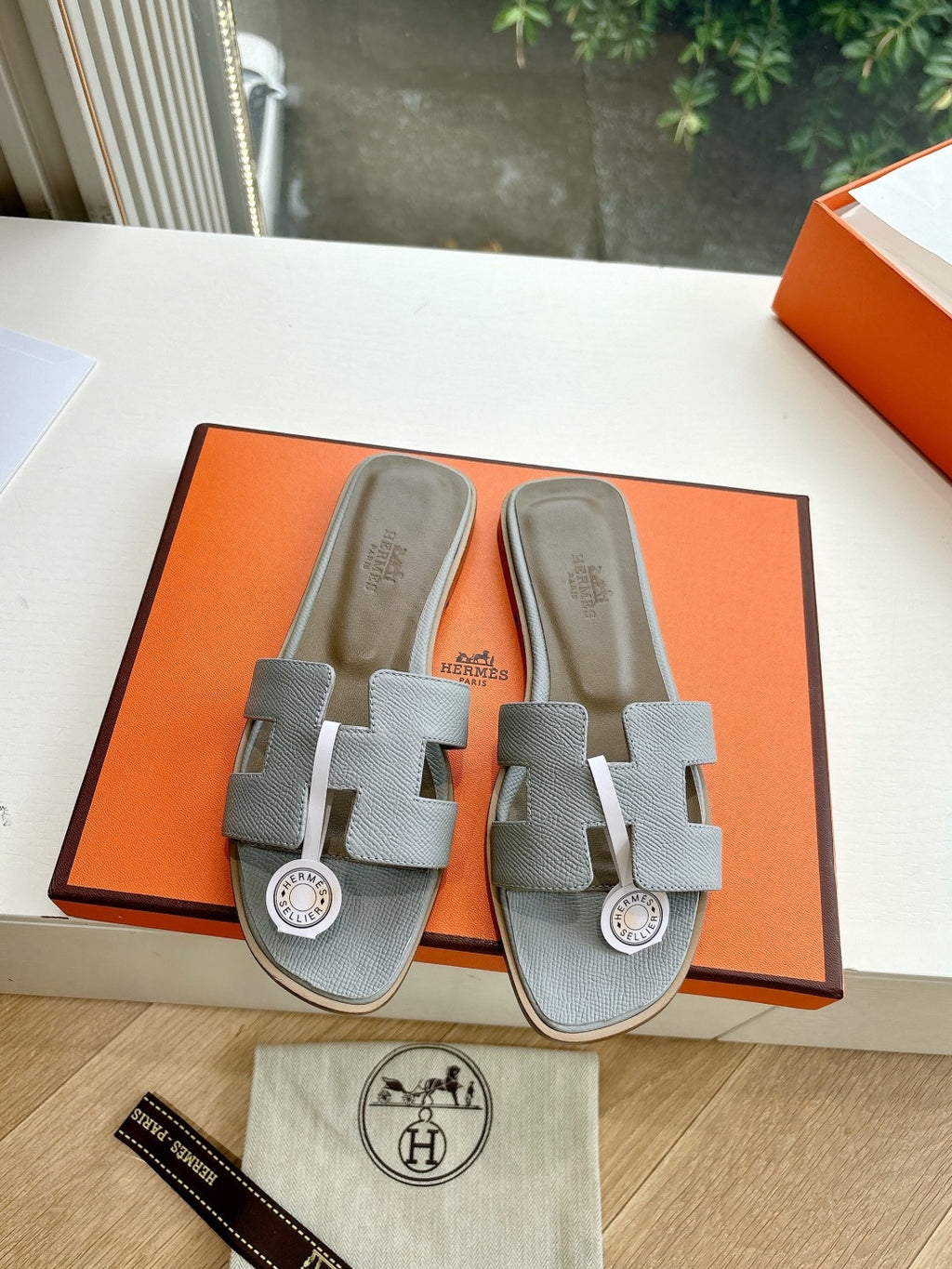 Hermes slide sandals pair in light gray textured leather with round H emblem