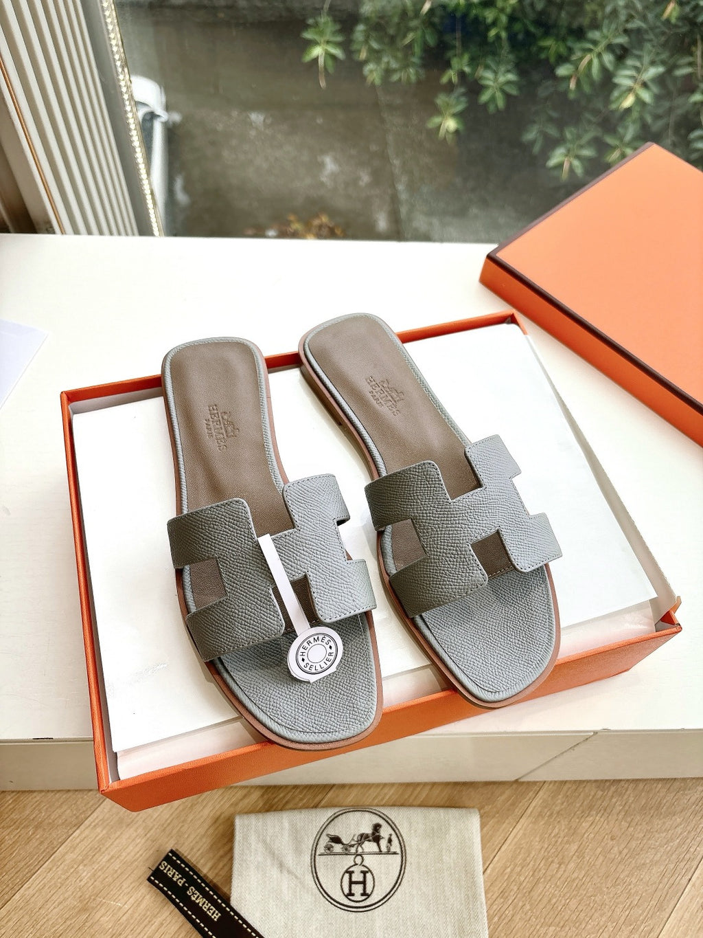 Hermes grey slide sandals with two wide straps and circular logo medallion