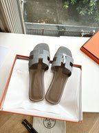 Hermes grey slide sandals, side-by-side pair with cushioned footbed and straps