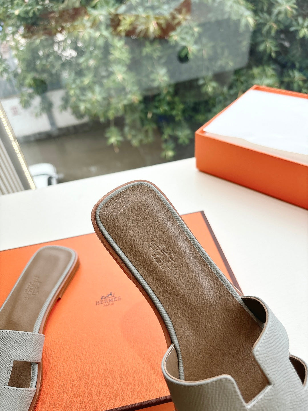Hermes grey slide sandal interior close-up, cushioned footbed and strap edge