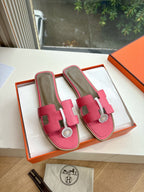 Hermes pink leather slide sandals with adjustable strap and circular emblem buckle