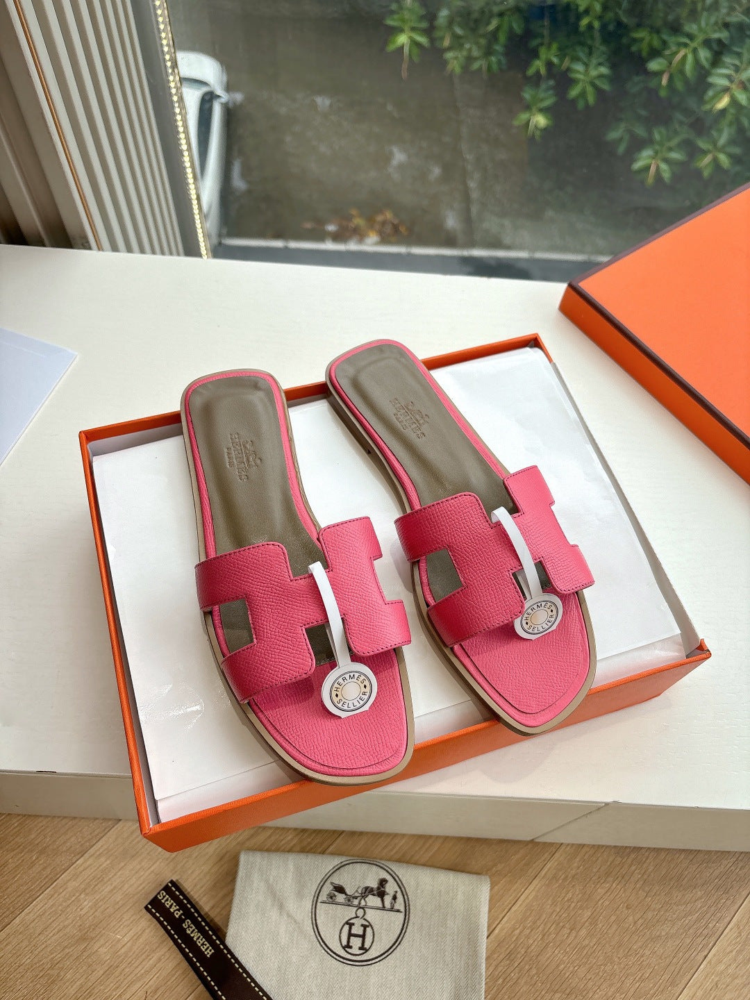 Hermes pink leather slide sandals with adjustable strap and circular emblem buckle