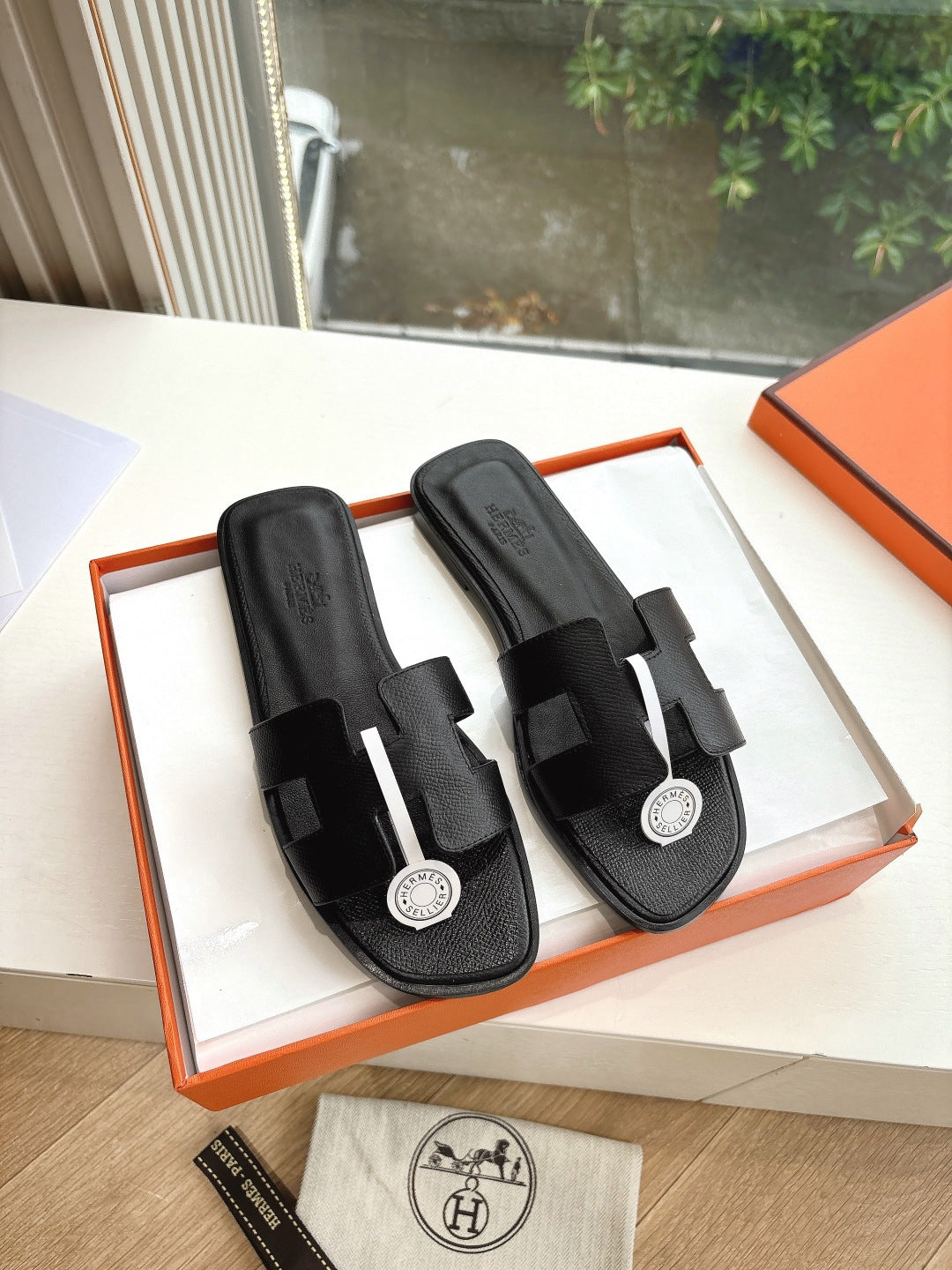 Hermes slide sandals in black leather with adjustable straps and round logo hardware