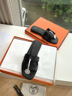 Black Hermes slide sandals with hook-and-loop straps and round logo medallion