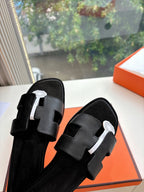 Hermes black leather slide sandals with textured straps and circular logo hardware