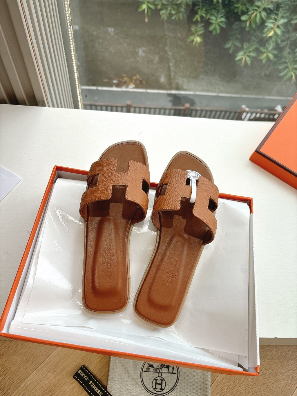 Hermes tan slip-on sandals with geometric straps and open toe design