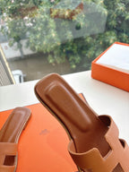 Hermes tan slide sandals with smooth leather footbed and open toe strap cutouts