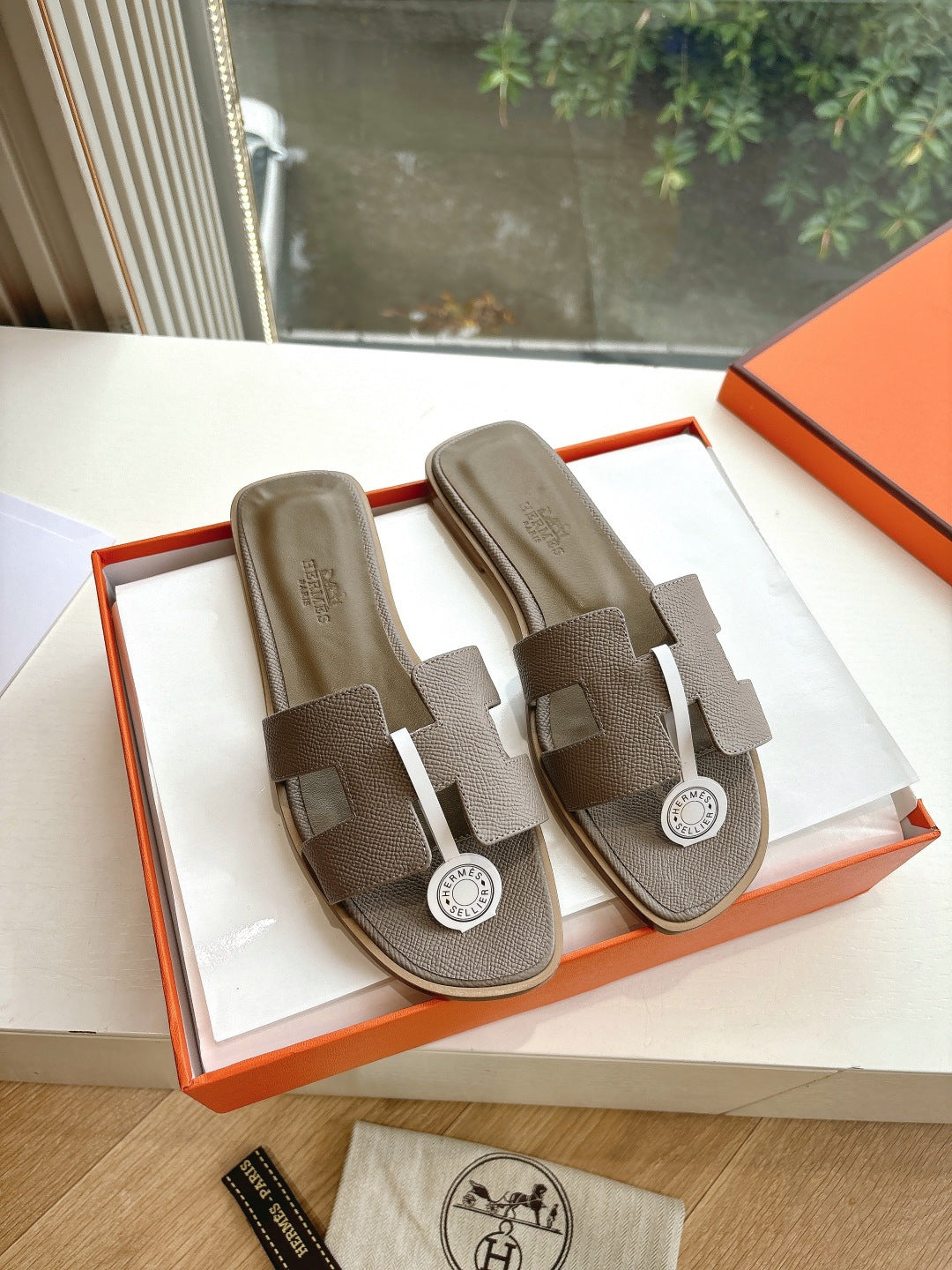 Taupe Hermès slide sandals with adjustable straps and round logo medallion