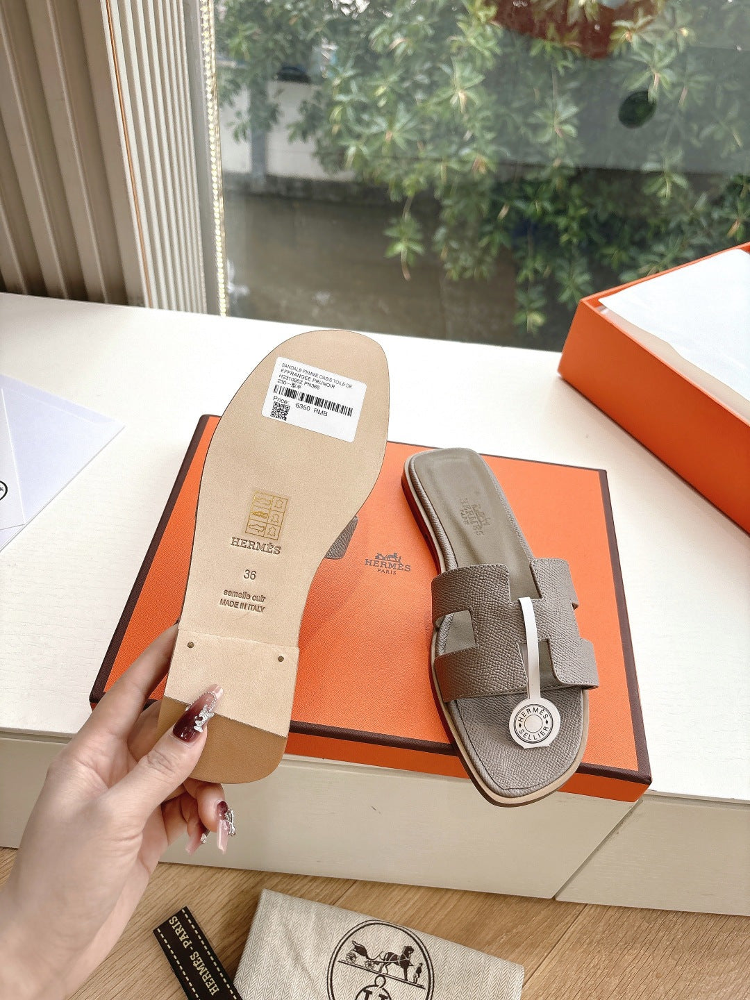 Hermès slide sandals with size tag display, taupe straps and round logo medallion
