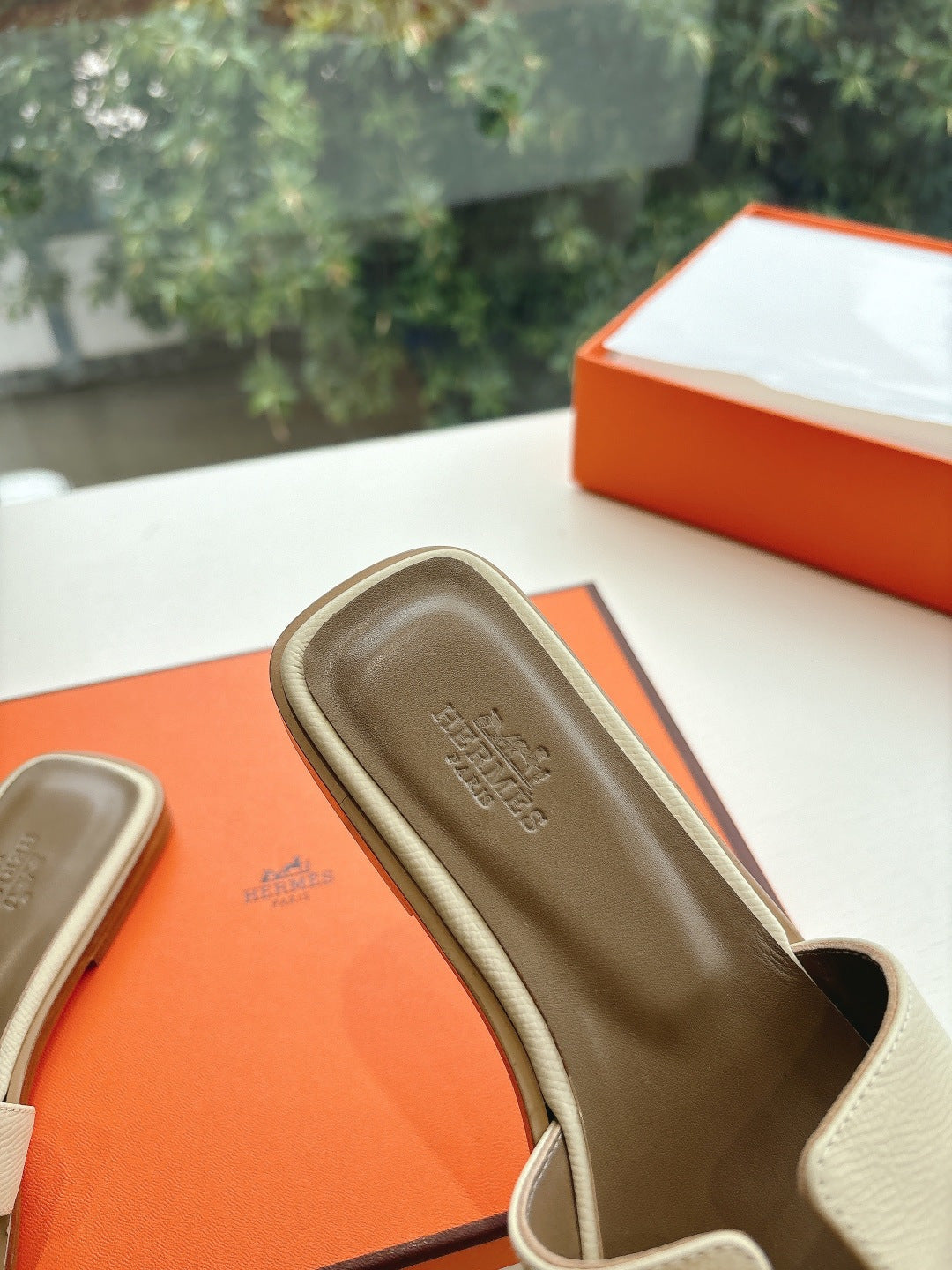 Hermes slide sandal in light beige with embossed logo on footbed