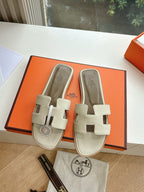 Hermes slide sandals in light beige with twin straps and round logo medallion