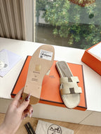 Hermes slide sandals in light beige with two straps and embossed sole branding