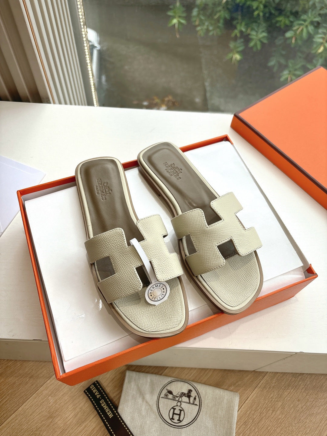 Hermes slide sandals in light beige with double strap and circular logo charm