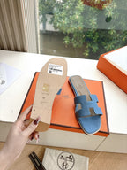 Blue Hermes slide sandals with H cutout; size label and inner sole visible
