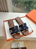 Hermes ladies slide sandals with dark navy and light blue woven straps, brown leather footbed
