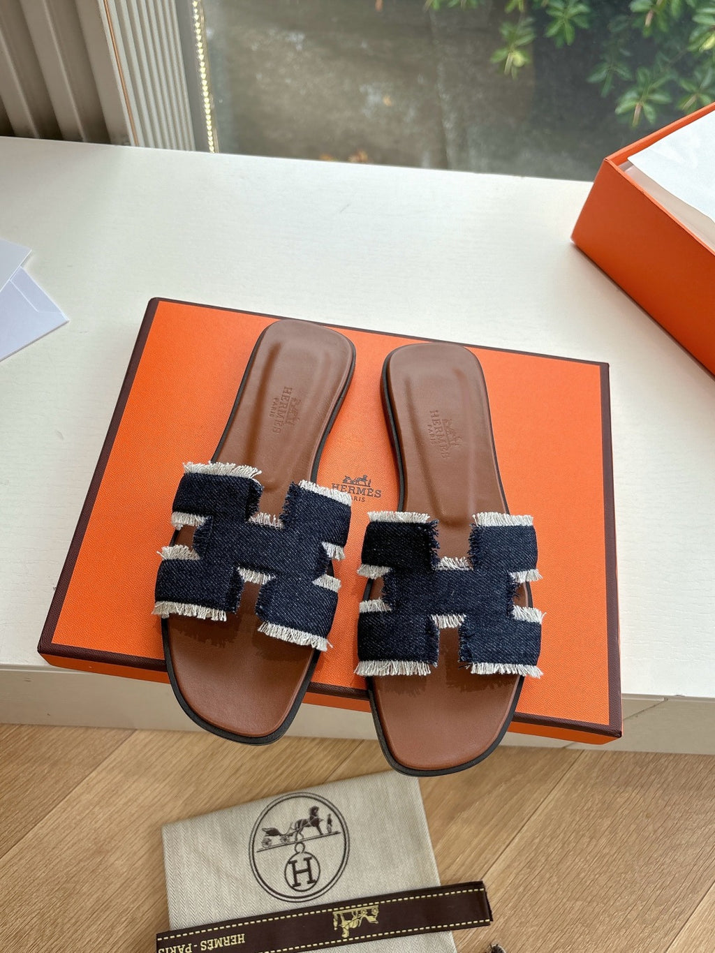 Hermes slide sandals on orange box base, brown leather with dark navy and light blue strap panels