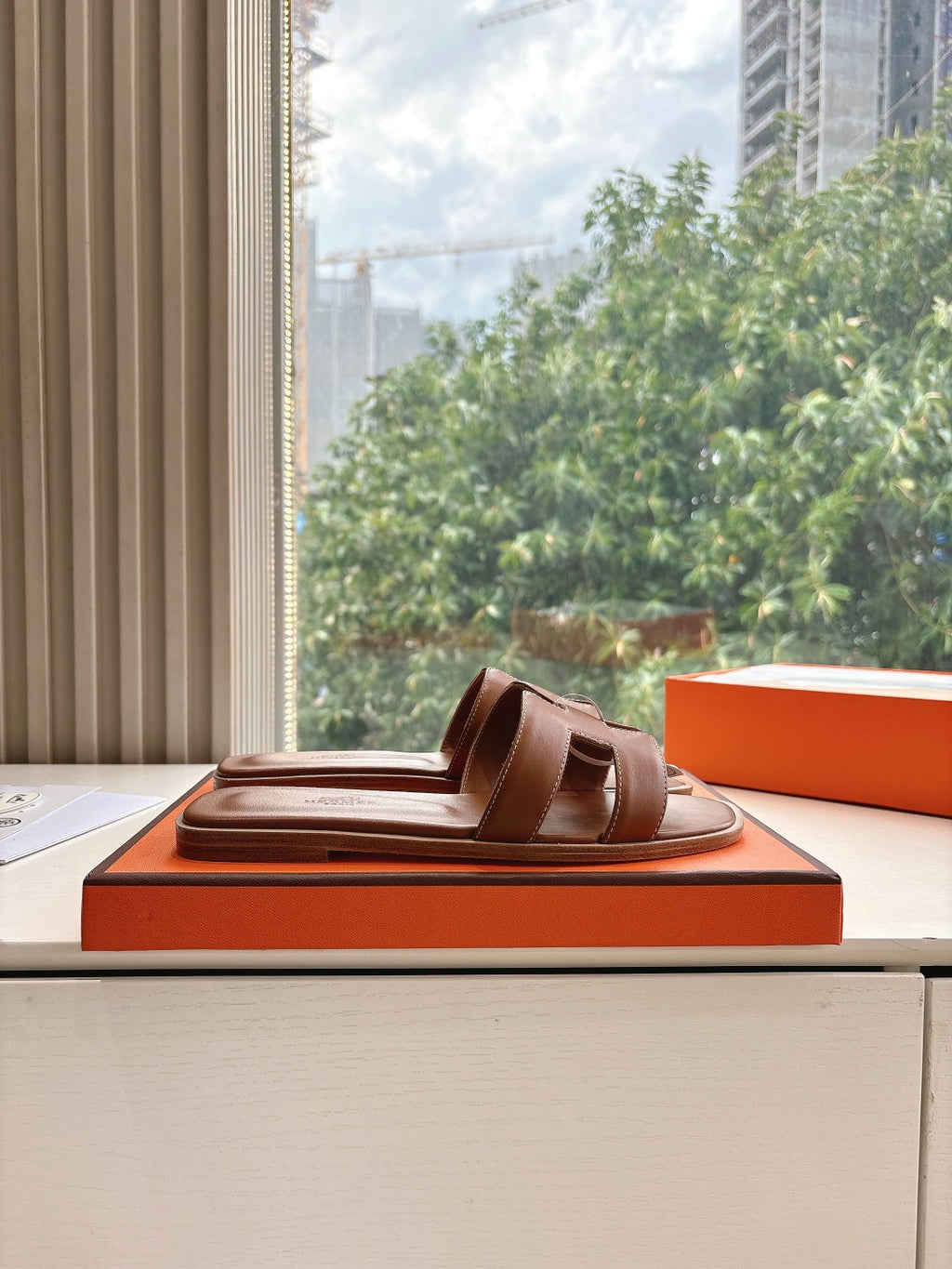 Hermes leather slide sandal on box, brown with two-bar strap
