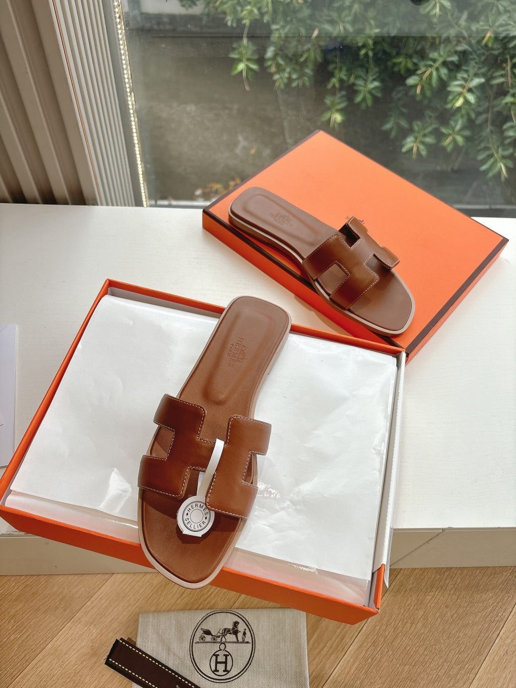 Hermes leather slide sandals with open toe and logo medallion, brown
