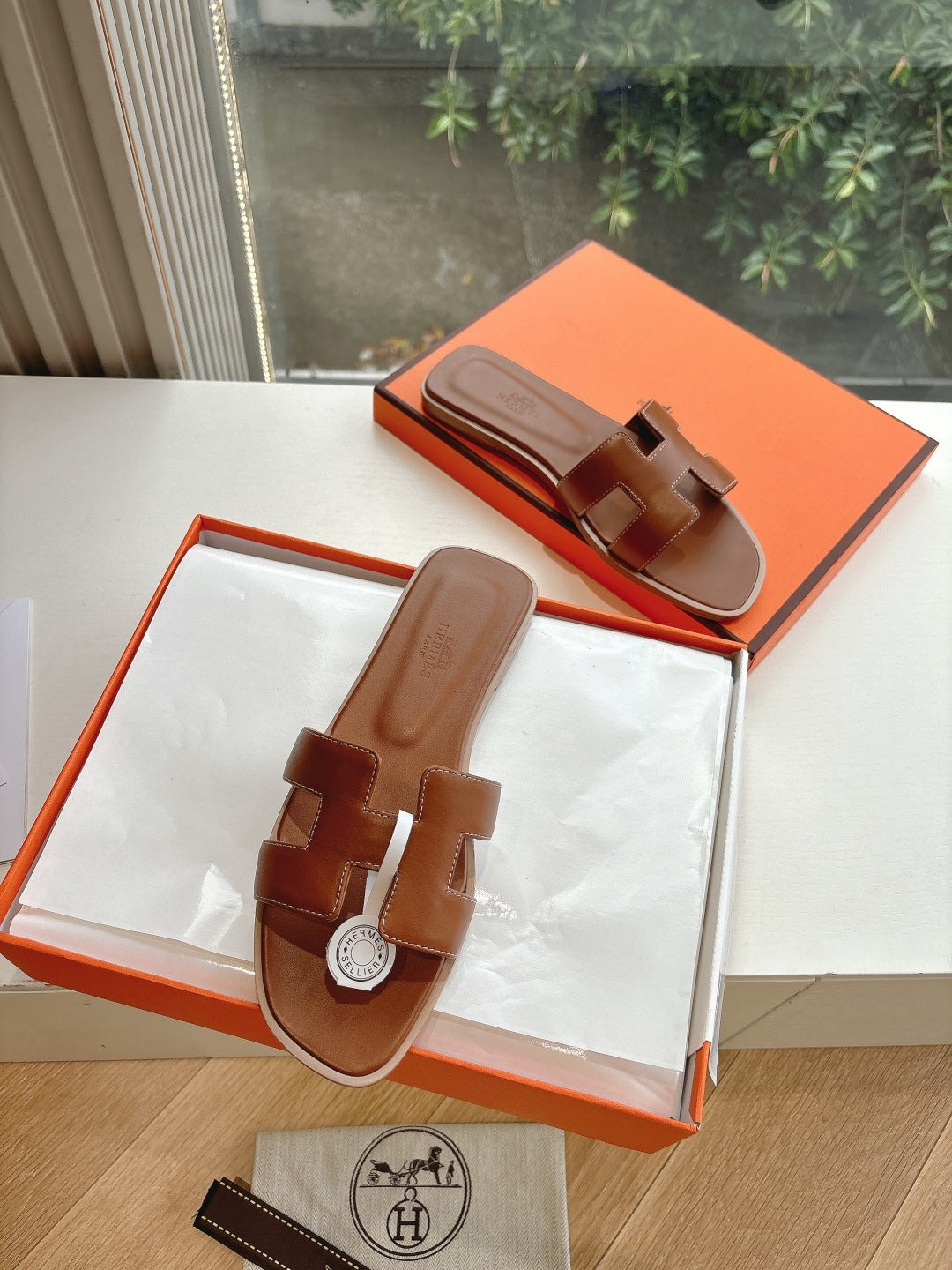 Hermes leather slide sandals with open toe and logo medallion, brown