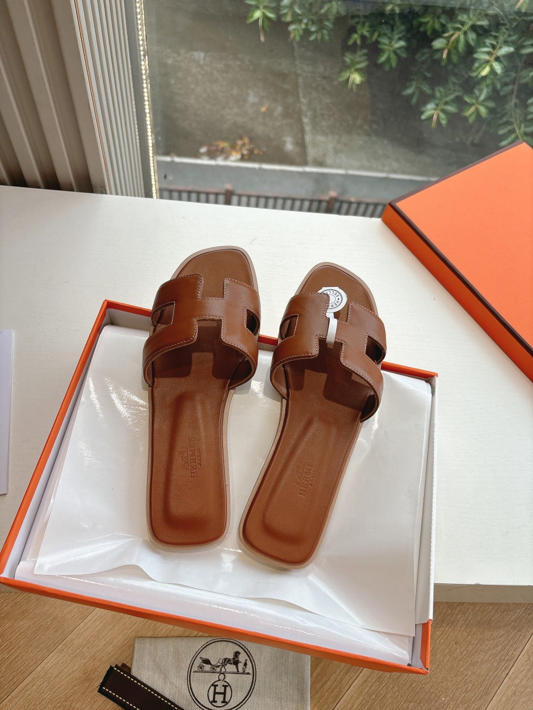 Hermes leather slide sandals, front view with buckle straps, brown