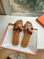 Hermes women's tan slide sandals, two-strap design with silver-tone round logo medallion