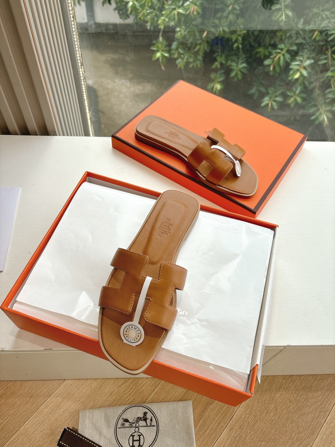 Hermes women's tan slide sandals with double buckle straps and round logo medallion