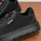 Black mesh and leather sneaker side with PRADA stripe branding and rugged sole
