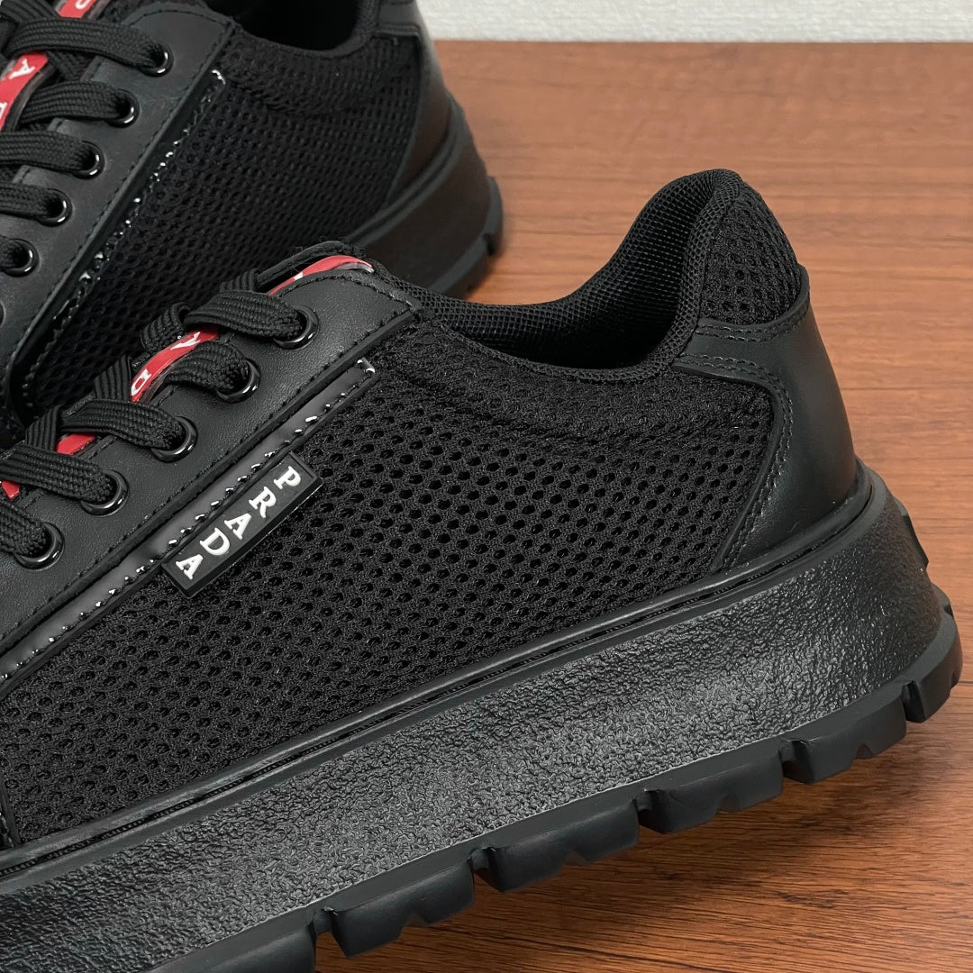 Black mesh and leather sneaker side with PRADA stripe branding and rugged sole