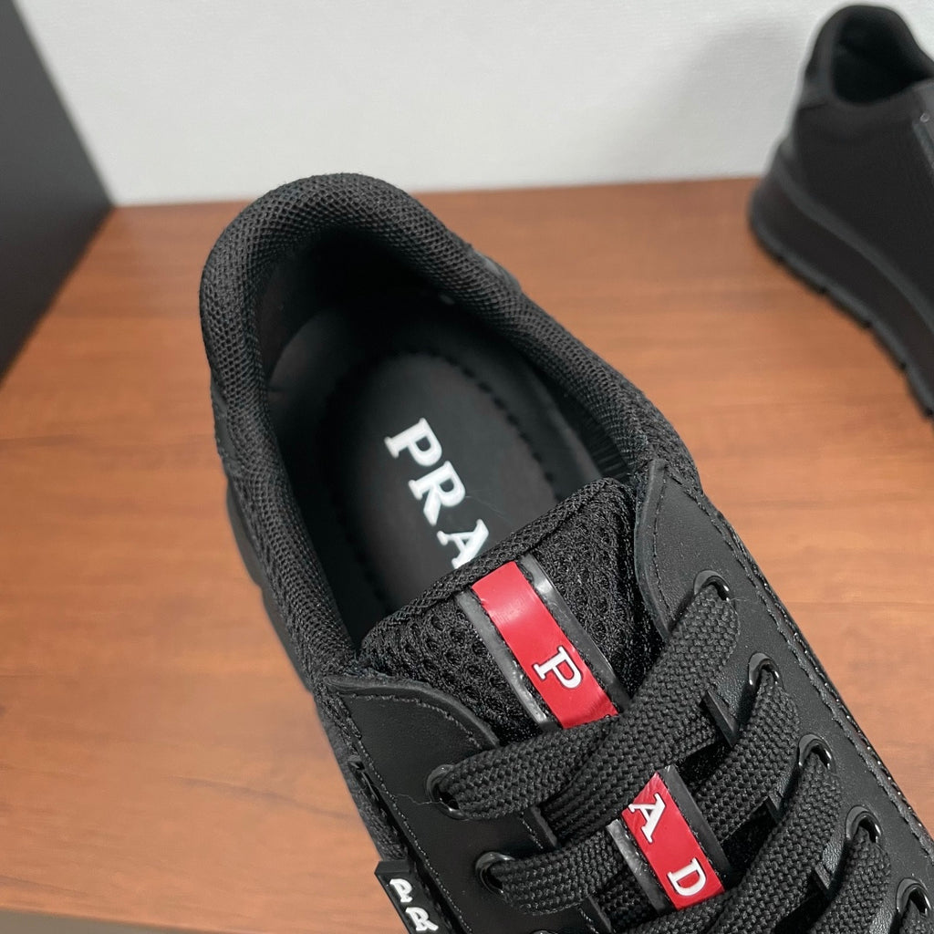 Black sneaker tongue and laces with red-and-white PRADA badge detail