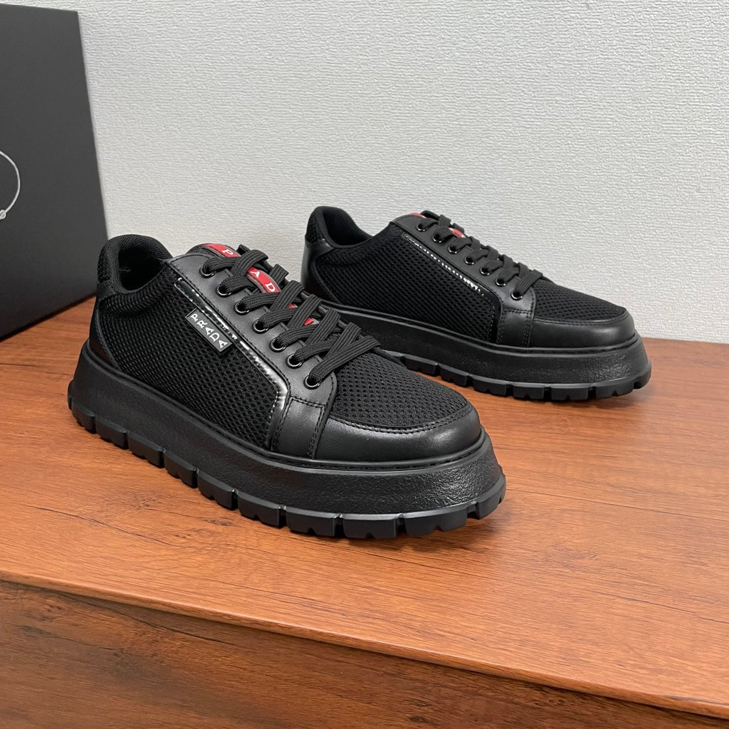 Black lace-up sneakers with textured mesh panels, leather details, and red/white logo
