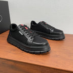 Black lace-up sneakers with textured mesh panels, leather details, and red/white logo