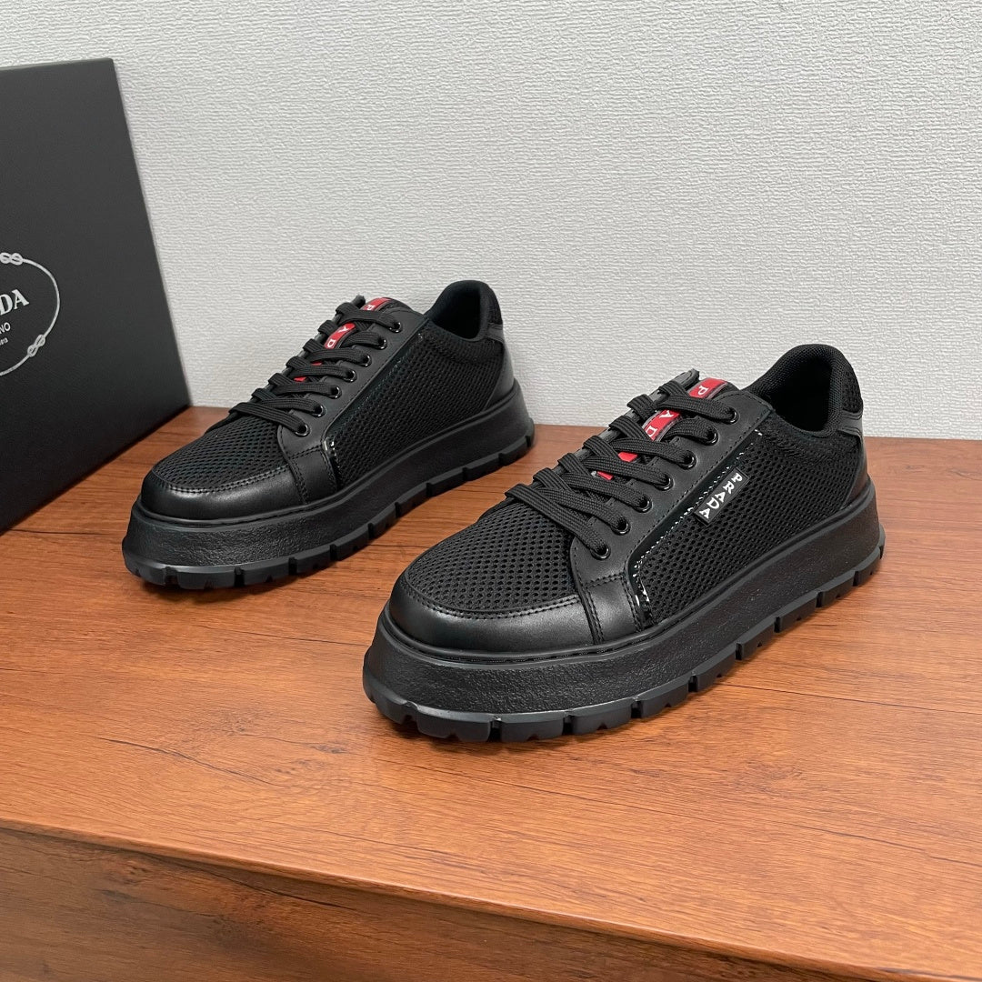 Black lace-up sneakers with mesh upper, leather panels, and chunky rubber sole