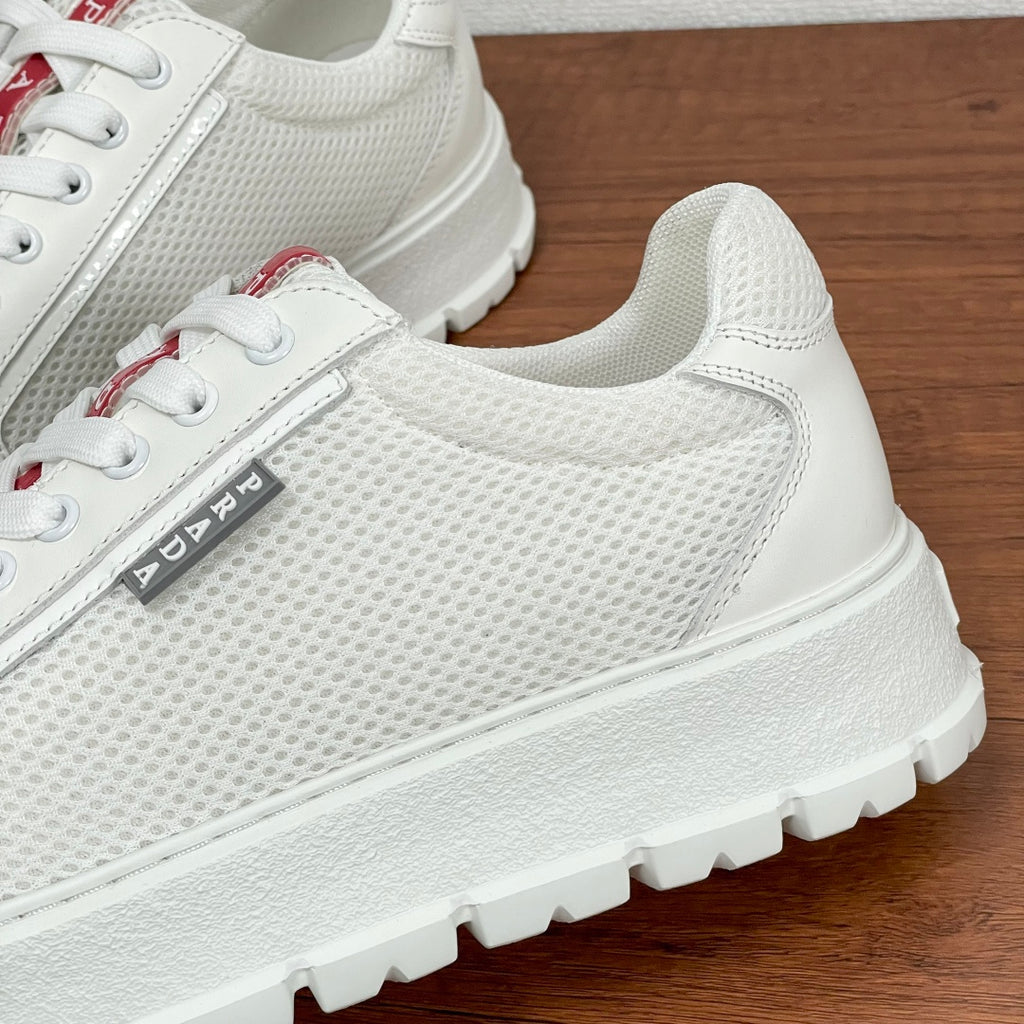 Unisex sneakers, close-up of white textured upper, lace panel and side logo tab