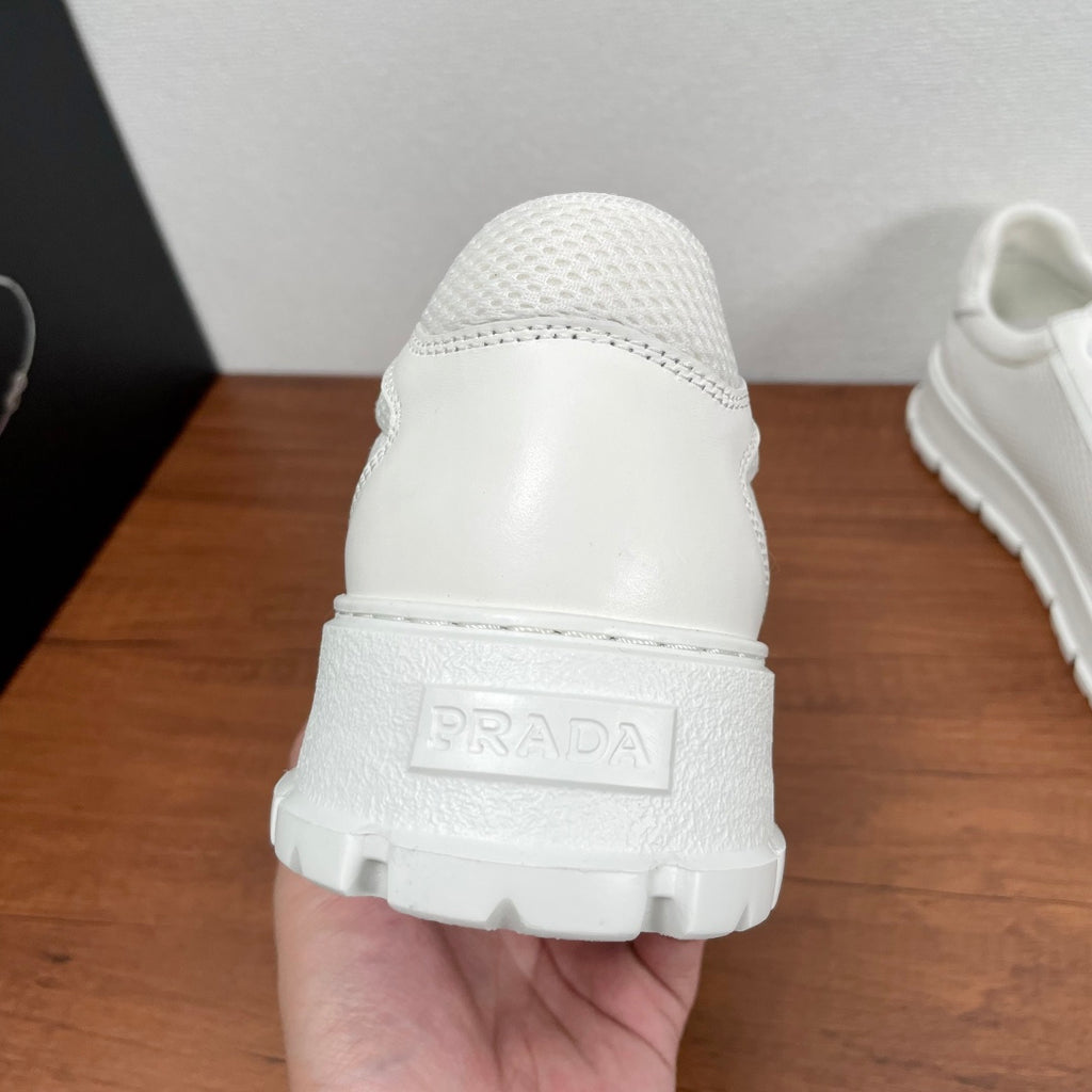 Unisex sneakers, white back view, cushioned collar, embossed Prada logo on heel
