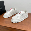 Unisex Prada sneakers, white textured uppers, lace-up, red/black tongue logos