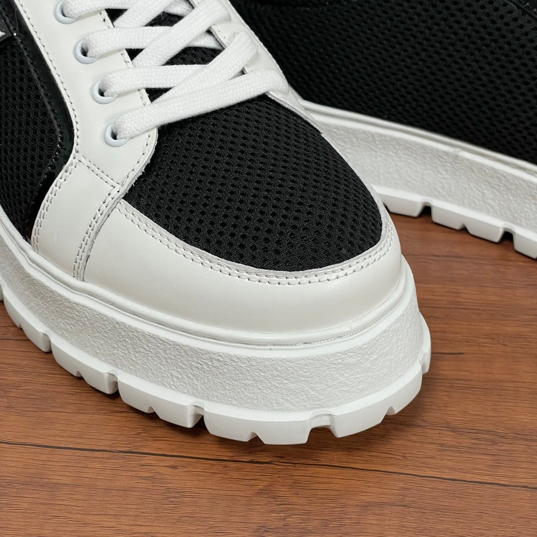 Prada unisex sneakers toe close-up, white leather toe cap over black mesh, lace-up sole