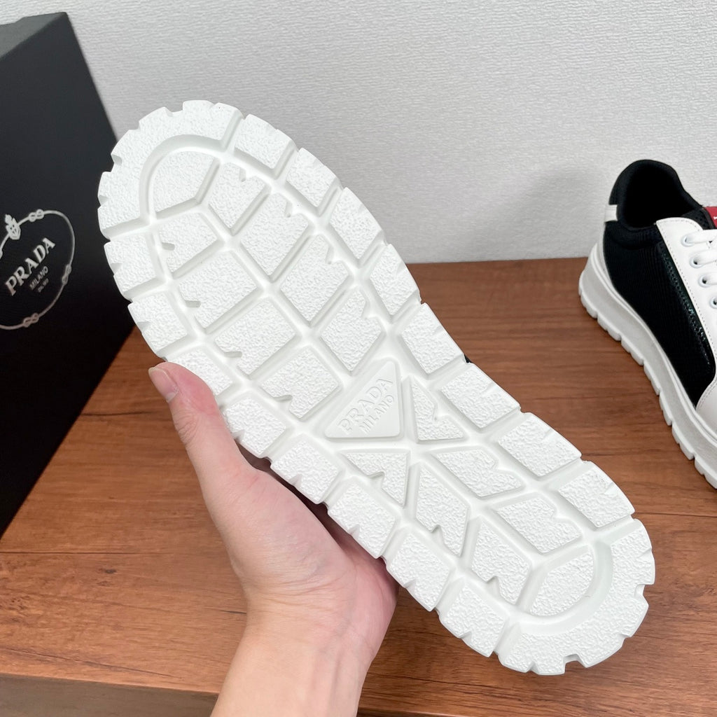 Prada unisex sneakers outsole view, textured rubber tread, embossed logo on heel