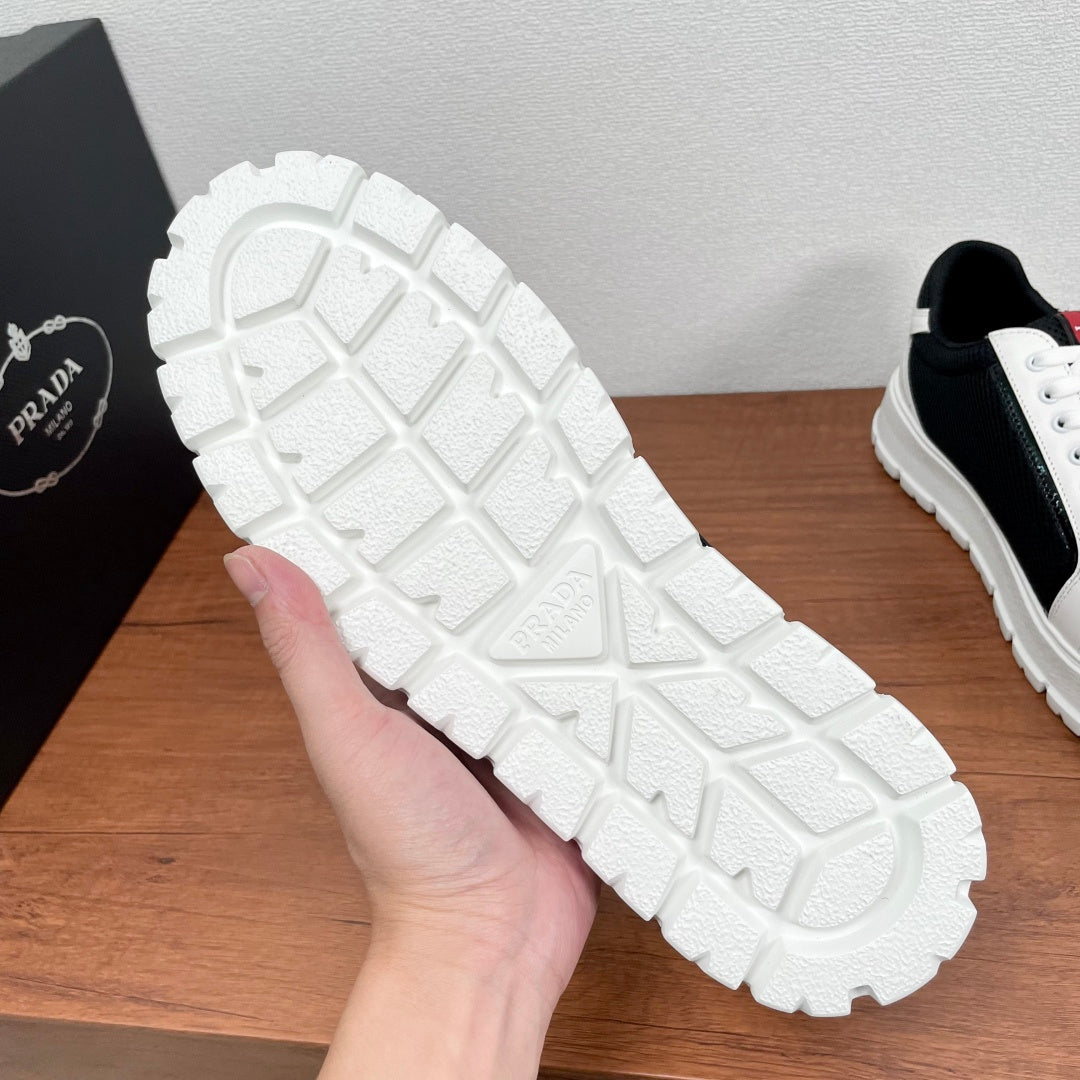 Prada unisex sneakers outsole view, textured rubber tread, embossed logo on heel