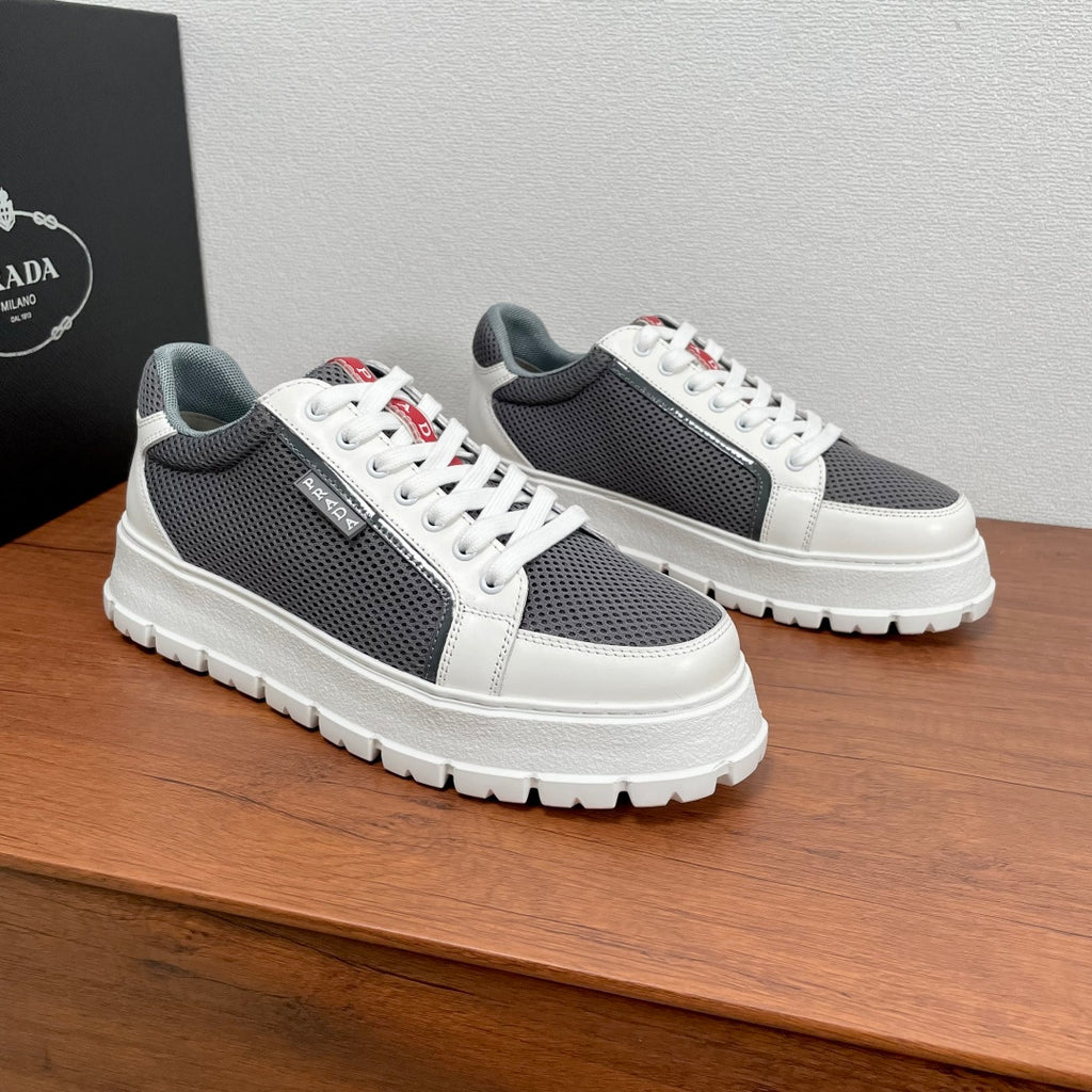 Prada unisex sneakers, front side view: gray mesh upper, white leather panels, red tag
